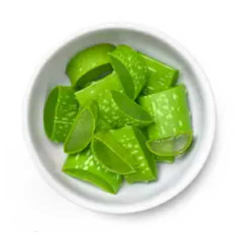 Aloe Vera slices sitting in a white bowl on a white background